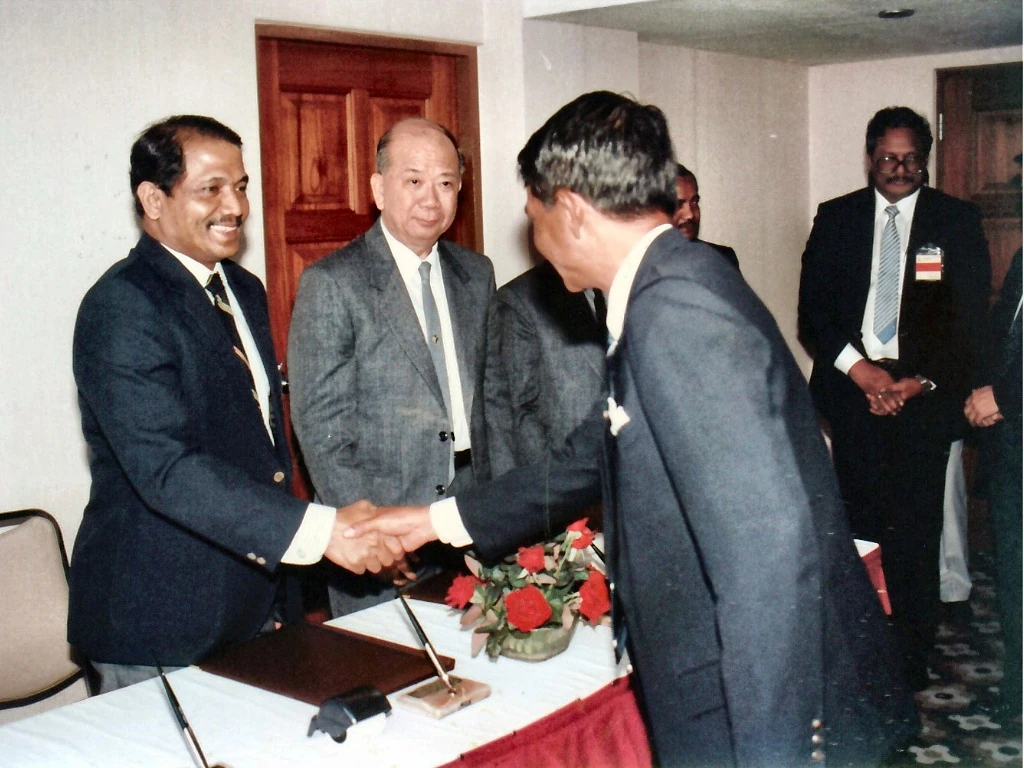 1989年12月2日签署《行政安排备忘录》后，马方谈判代表团团长拿督拉欣诺（左一）与泰方将领（右）握手致贺，陈平总书记（左二）与扎曼汗（右后）在场见证