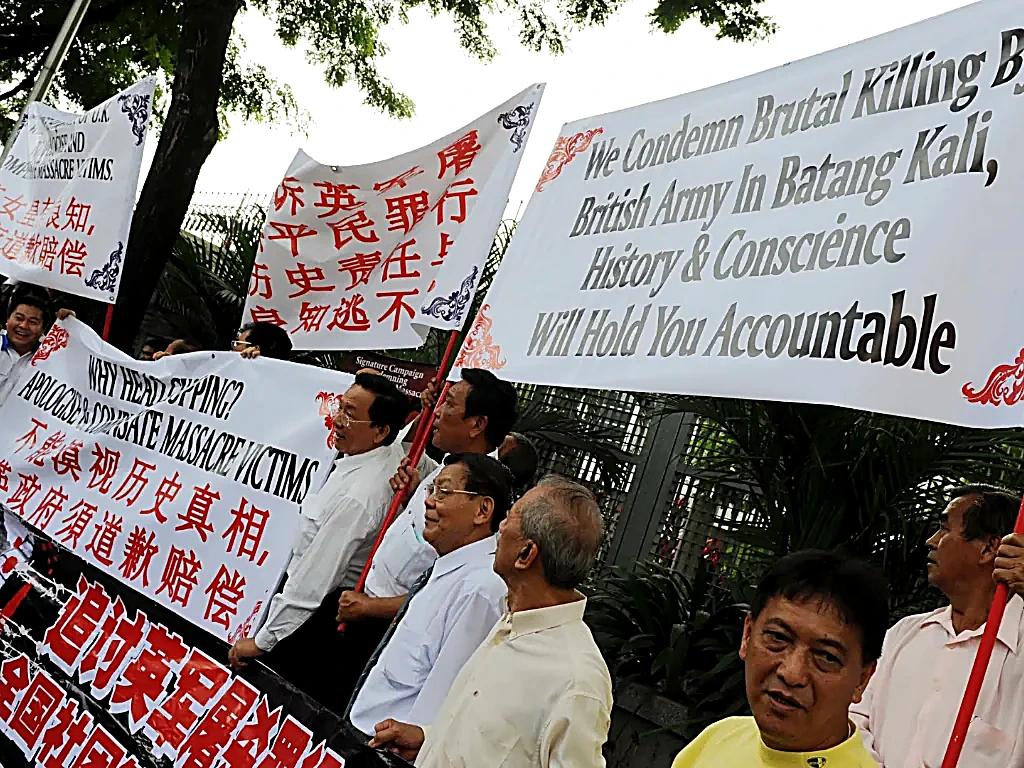 2015年11月25日英国最高法院作出判决后的吉隆坡抗议现场：受害者家属与大马民间维权团体在英国驻马最高专员署前高举横幅与遇难者遗像，誓言追索正义到底。