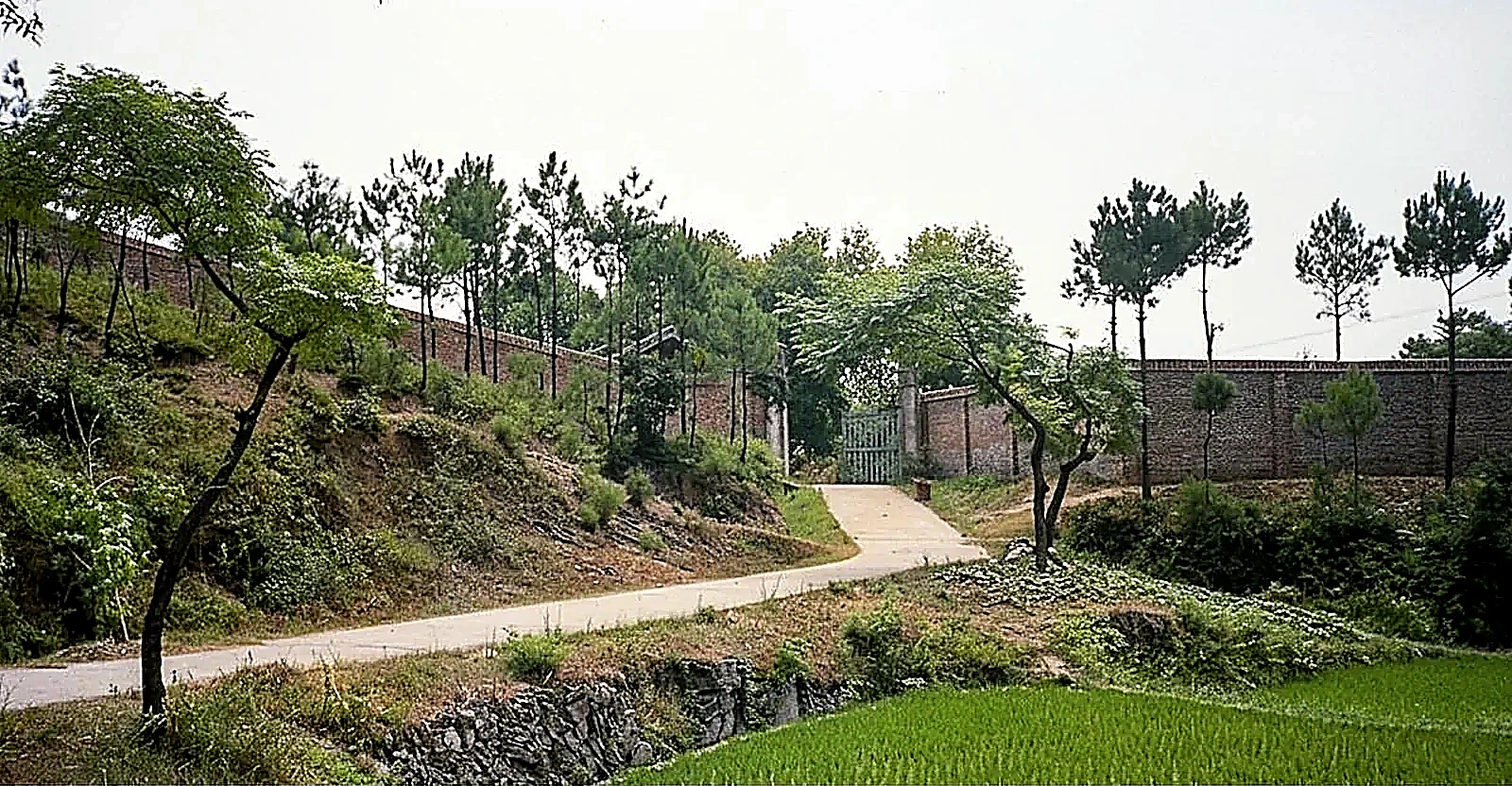 湖南益阳四方山“691工程”军管营区外围高耸红砖岗哨围墙与铁门入口