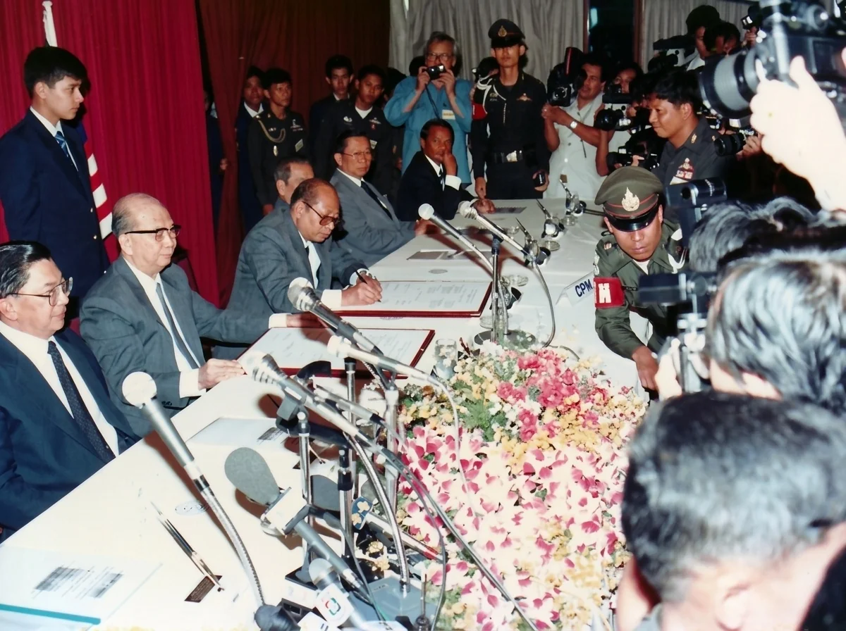 1989年12月2日合艾签署大典马共代表席（左起：差瓦立上将、陈平、正在挥毫签署的阿都拉·西迪、拉昔·迈丁、吴一石、吉迪将军）