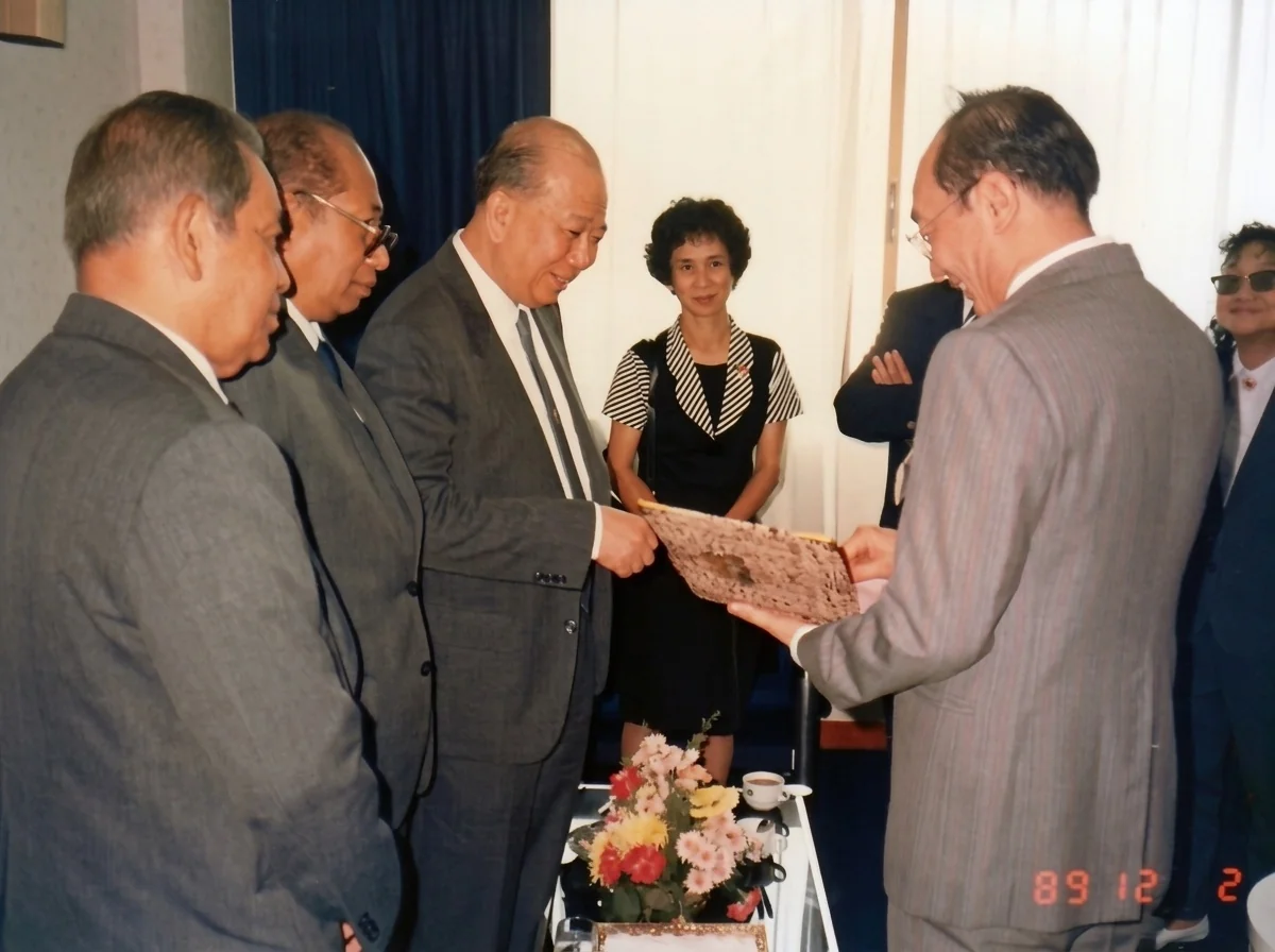 1989年12月2日合艾贵宾厅内，拉昔·迈丁（左一）、阿都拉·西迪（左二）、陈平（左三）在纪念册上签名留念后交还与会嘉宾（右二），中为随团女翻译，后方抱臂者为吉迪将军，右一为与会女嘉宾