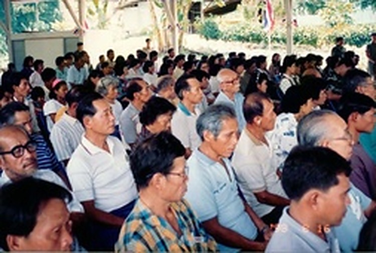 1993年8月：和平村白发苍苍的老战士与村民们整齐端坐在礼堂内，聆听朱拉蓬公主发表讲话。