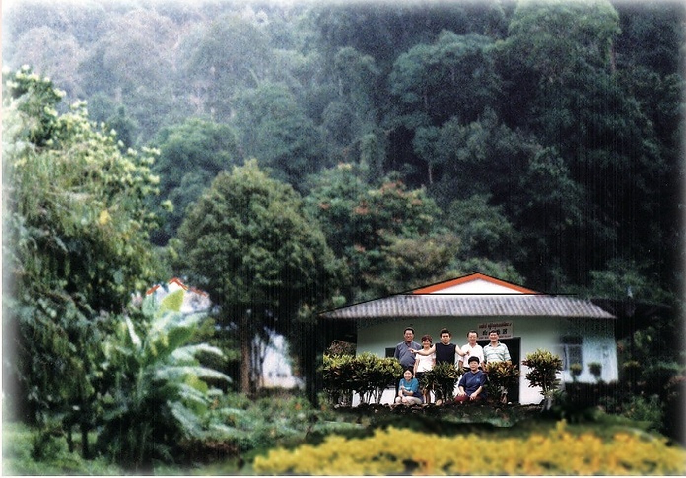 邦朗和平村（Banglang Peace Village，第9朱拉蓬公主发展村 / Ban Chulabhorn Patana 9）：原马来亚人民军第八支队指战员定居点。图为村民与家属在背靠苍翠原始雨林、门前鲜花盛开的村委会平房前合影。