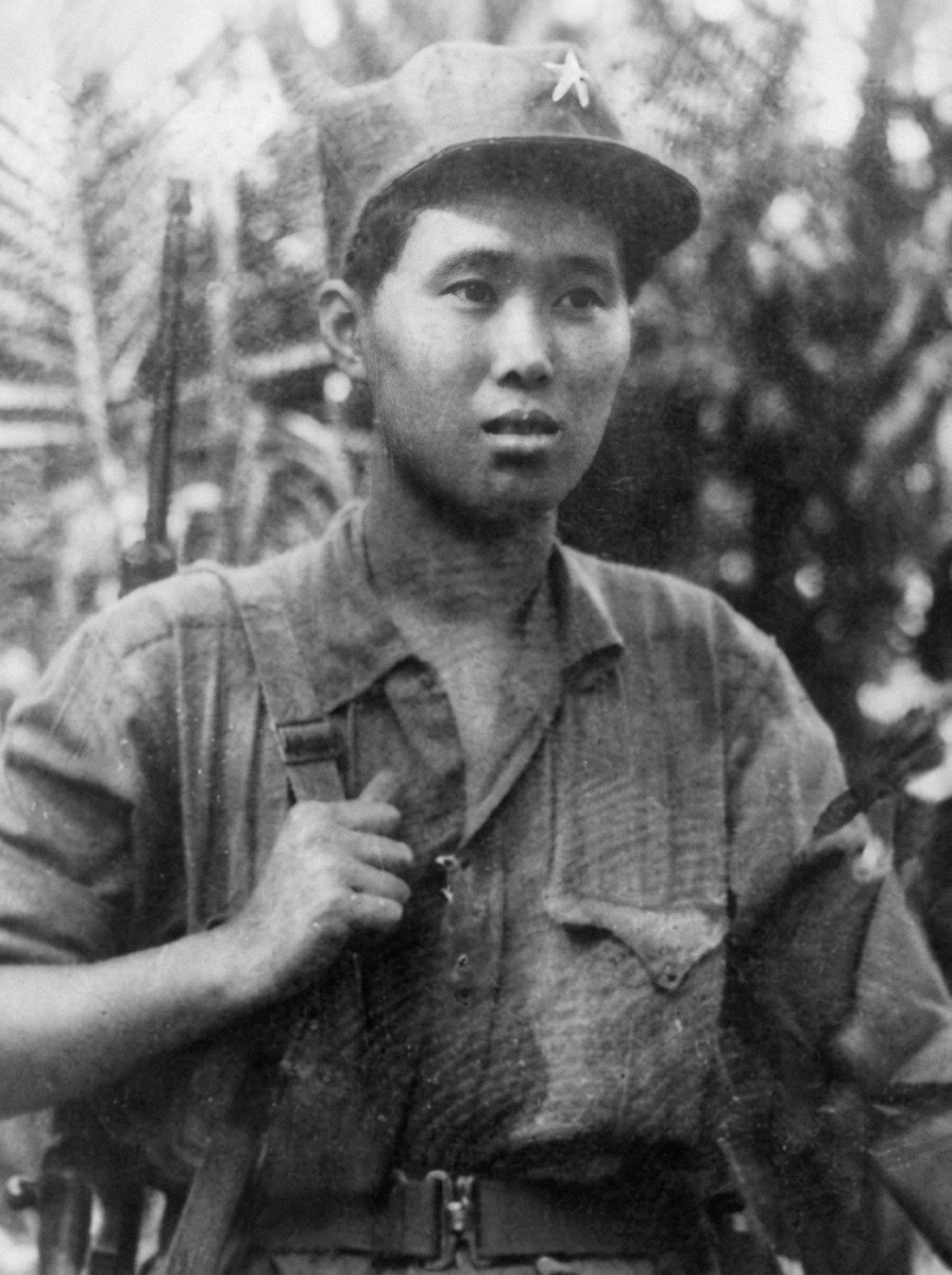 1956年10月战略北撤期间，肩背步枪的马来亚民族解放军战士纪念肖像，真实呈现1950年代森林游击队员的单兵装具与风貌。