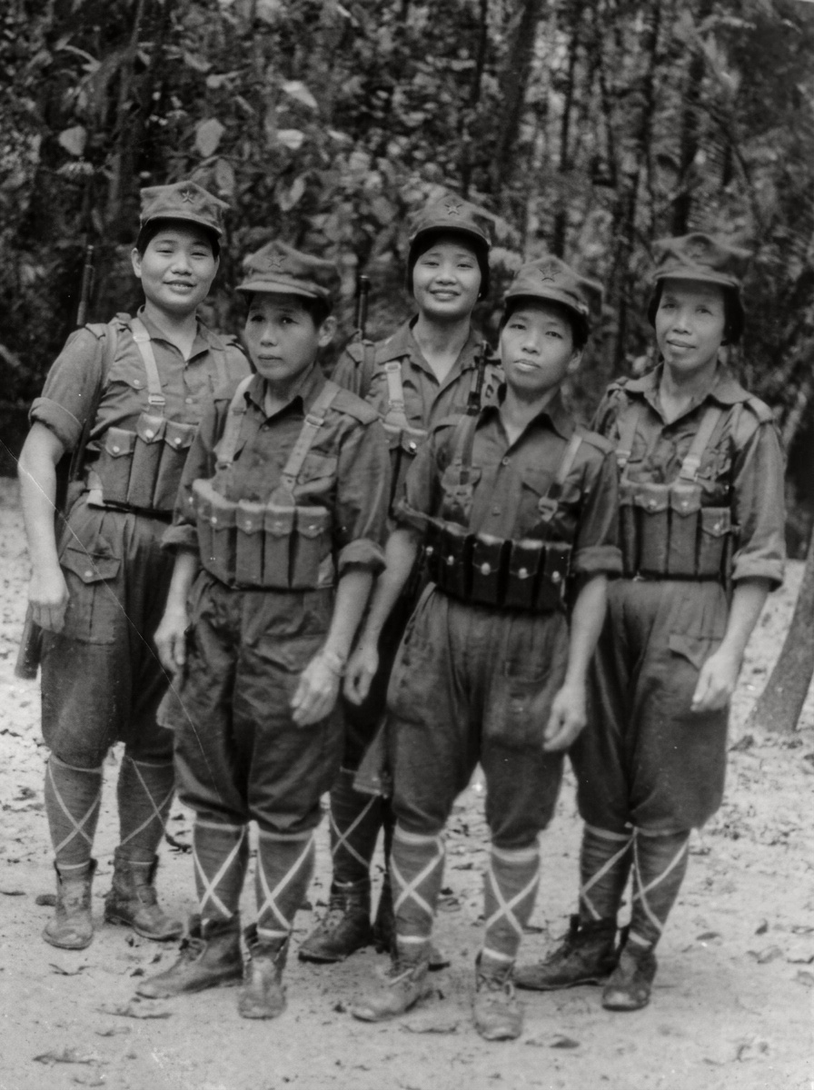 1986年驻防泰马边境“坚持营房”的五名马来亚人民军女战士身着军装、胸佩弹匣袋在林间空地合影。