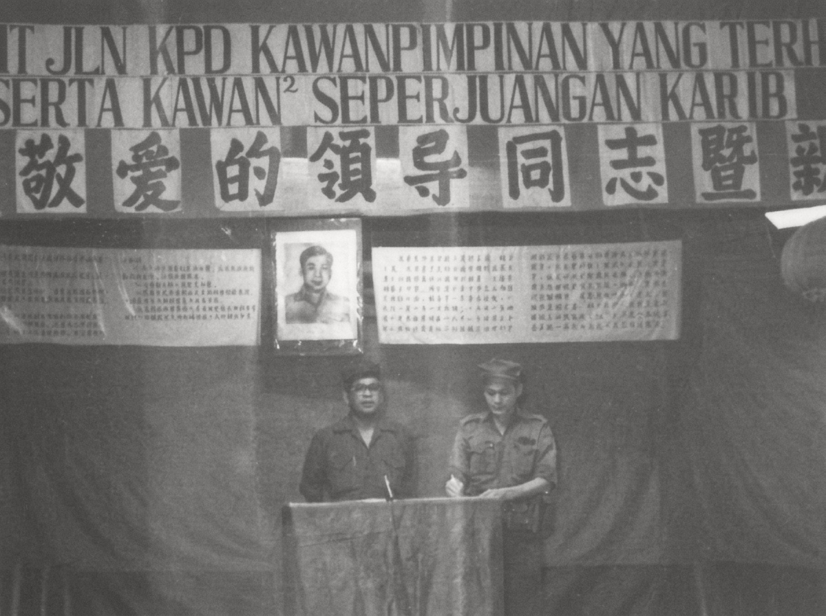 1979年3月14日，密林大本营举行欢迎第十支队创建者阿都拉·西迪（党内尊称“拿督 Datok”）暨欢送战友华巫双语大会，马共中央与北马局领导人（左）在陈平画像下发表讲话，右侧干部现场口译为马来语。