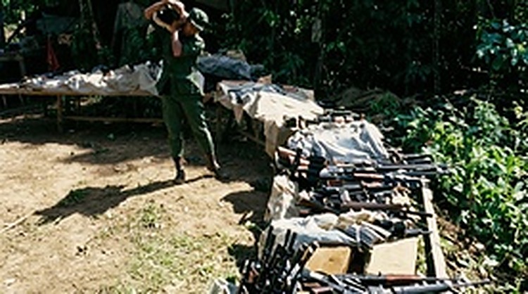 丛林营地内延绵数十米的武器陈列台：人民军某部将全连队的轻重武器悉数上架，举行庄严的告别枪支仪式。