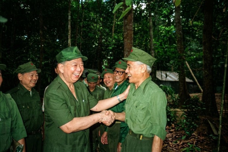 1989年12月《合艾和平协议》签署后，马共中央总书记陈平（左）重返泰马边境密林营地，与久别重逢的白发老战友紧握双手、搭肩相拥，定格下灿烂的“和平的容颜”。