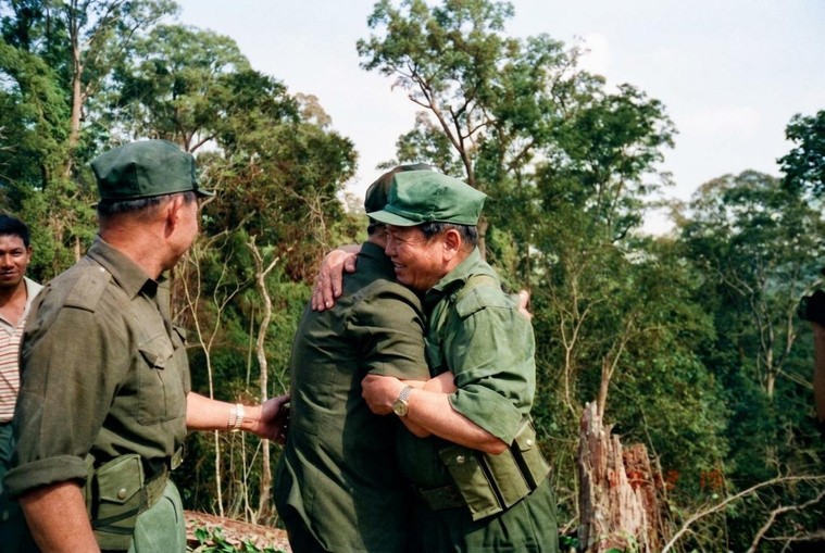 1989年12月19日，历经数十载丛林烽火考验的老战友在泰马边境密林营地重逢时紧紧相拥，互庆劫后余生与和平曙光。