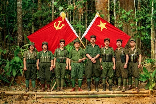 1970年代后期至1980年代马来亚民族解放军各支队指战员在边境丛林根据地高举马共党旗与军旗整装合影历史实照（第3帧）