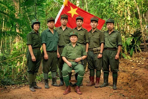 1970年代后期至1980年代马来亚民族解放军各支队指战员在边境丛林根据地高举马共党旗与军旗整装合影历史实照（第5帧）
